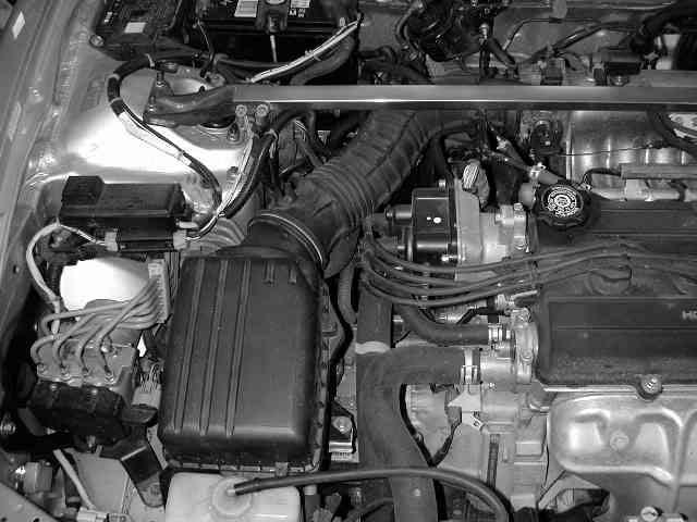 b) Remove the stock airbox and intake system by loosening the hose clamp around the throttle body and removing the two