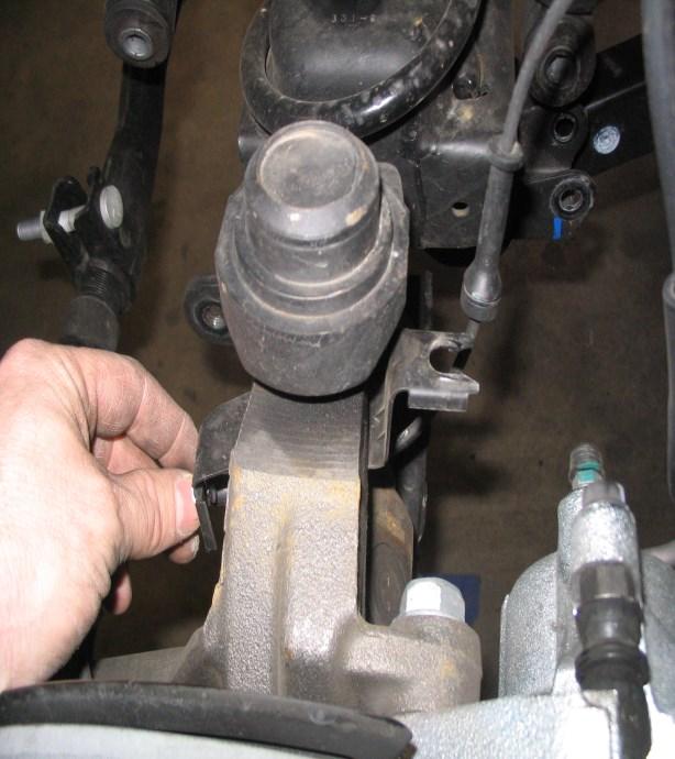 With the jack under the rear axle, jack up it up so you can disconnect the rear shocks