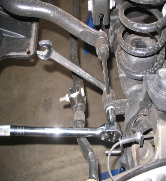Install the coil spring on the driver side first then the passenger