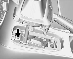 2. Release the shift lever trim from the center console at the rear, then fold upward and turn it to the left. 3. Insert a tool into the opening as far as it will go.