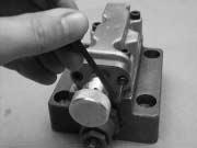 Remove the two socket head cap screws attaching the pressure adjustment cap to the body of the second stage by using