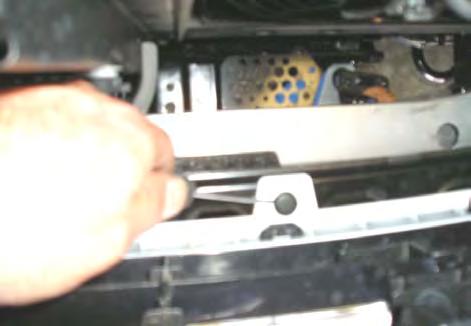 Remove plastic plugs securing upper bumper tabs to cross member. 23.