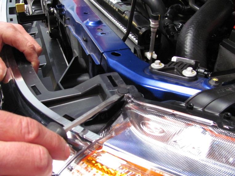 Remove the plastic clips from the top / rear corners of the grille.
