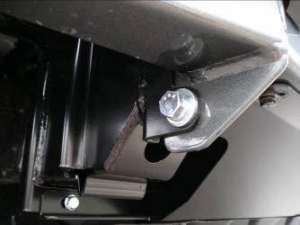 One hole is located in the lower lug of the mount face and one up above the welded nuts. Use access through the light surround opening for the top hole.