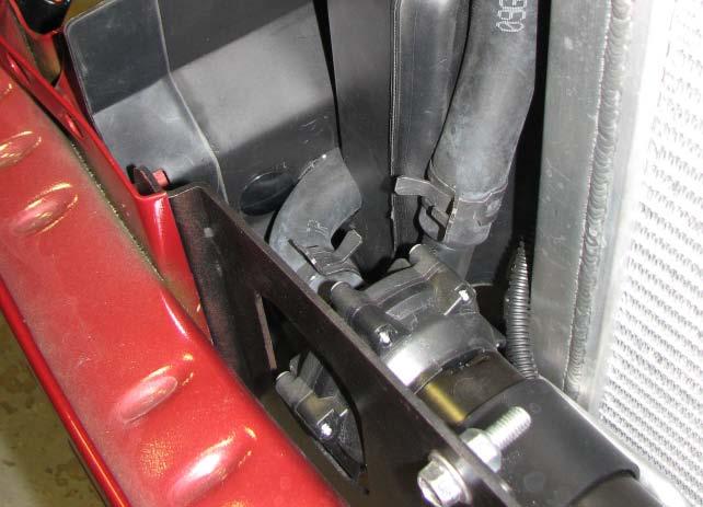 Hold the passenger side shroud in place to visualize where the hose will pass through it, then use a stepped