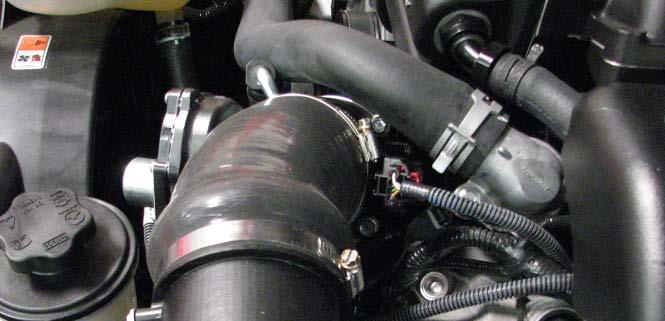 Install the supplied heater hose from step #99 onto the heater tube on the passenger side of the water crossover. 148.