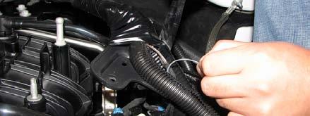 17. Remove the engine cover by lifting the front of the cover up to detach the clips, then lift the rear of