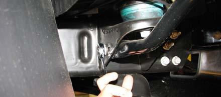 63. Remove two (2) bolts off the passenger side bumper support using a 15mm socket.