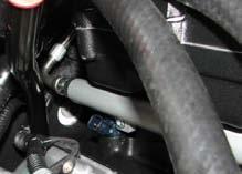 82. Install the supplied fuel cross-over hose onto the passenger side zinc 3/8 adapter and route it