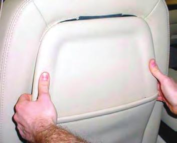 On the right and left sides of the upper portion of the seatback, insert a flat bladed tool (trim stick) between the seatback