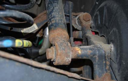 REMOVING THE ORIGINAL REAR SHOCKS AND SPRINGS Step 1: Using a 10mm socket, remove the nut (arrow)