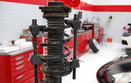 CAUTION Make sure the coil spring compressor is securely installed and the safety pins are engaged.