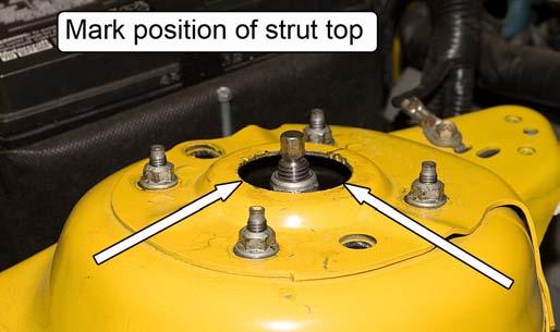 8. If using the factory upper strut mount, remove the four nuts retaining the strut mount plate to the vehicle.