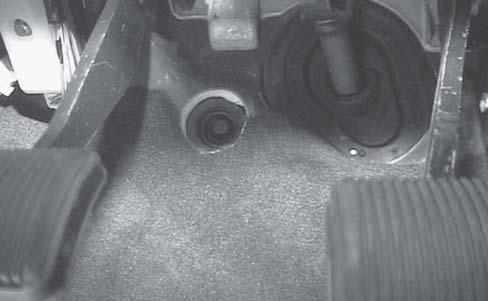 Locate the grommet in the floor panel behind the pedals as shown in figure 18b.