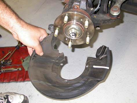 Once the retaining screws are free, rotate the dust shield on the hub, so that the caliper