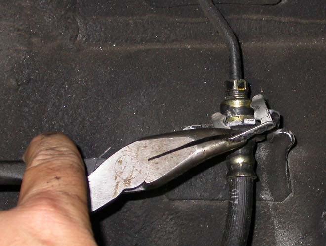 Place a drip tray or several rags directly below the inboard brake line connection.