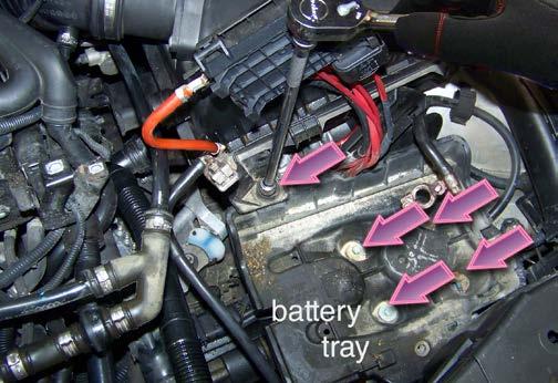 emove the Battery Tray Using a ratchet, extension, and 10mm socket, remove the four bolts at the base of the battery tray, plus the