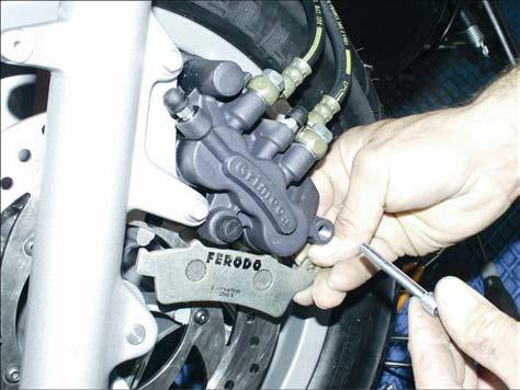 Release and remove the pin (3). Extract the brake pads.