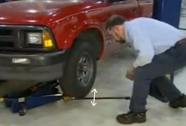 Typical Axial / Vertical Check For an axial check, first lift by lower control arm, test with a pry bar between the floor and tire to see if there is any vertical / axial movement.