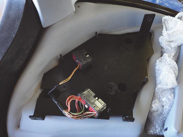 Remove the cover from the storage compartment in the left-rear corner of the cab.
