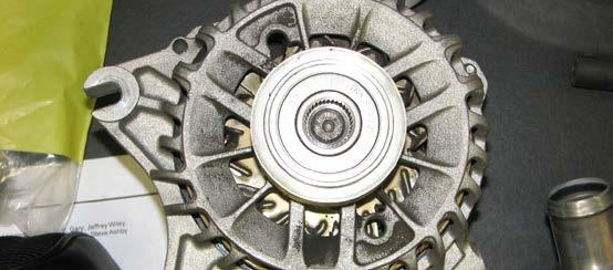 119. Use a flat head screwdriver to pop off the bearing cover on the alternator pulley.
