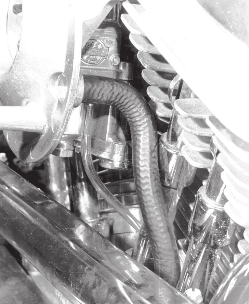 Install breather hose between breather fittings with long hose runner toward rear cylinder breather fitting.