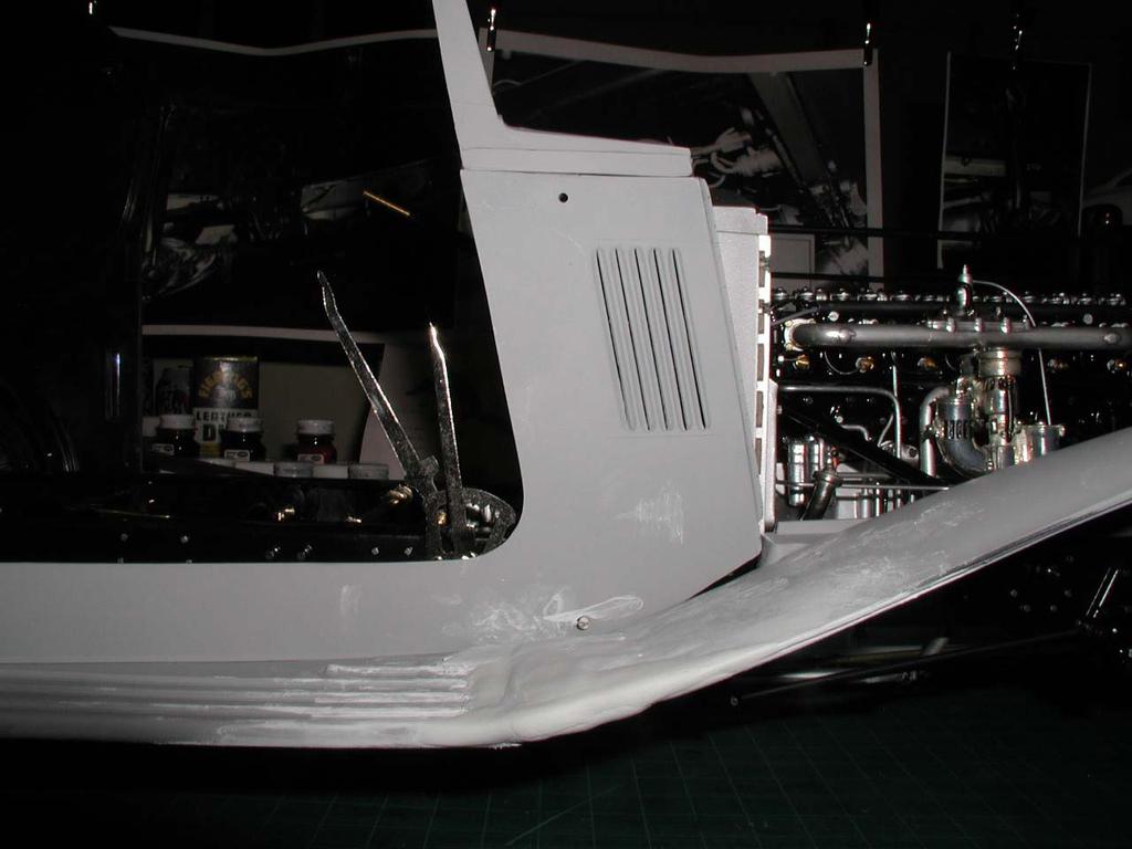 July 6, 2003 Now that the trailing edge of the front wings has been trimmed and reshaped, medium grade Milliput is applied to turn what were previously two parts into one continuous panel that will