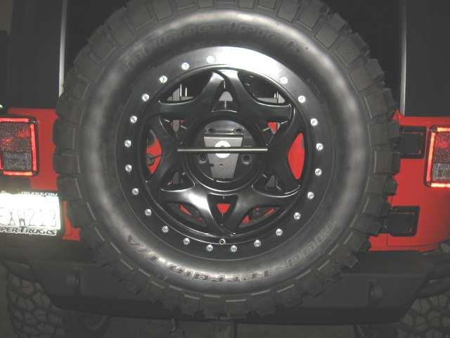 Step 7: Set your spare tire onto the center tube of the tire carrier. (Fig G) Place tire so that two of the lug nut holes are on top (side to side).