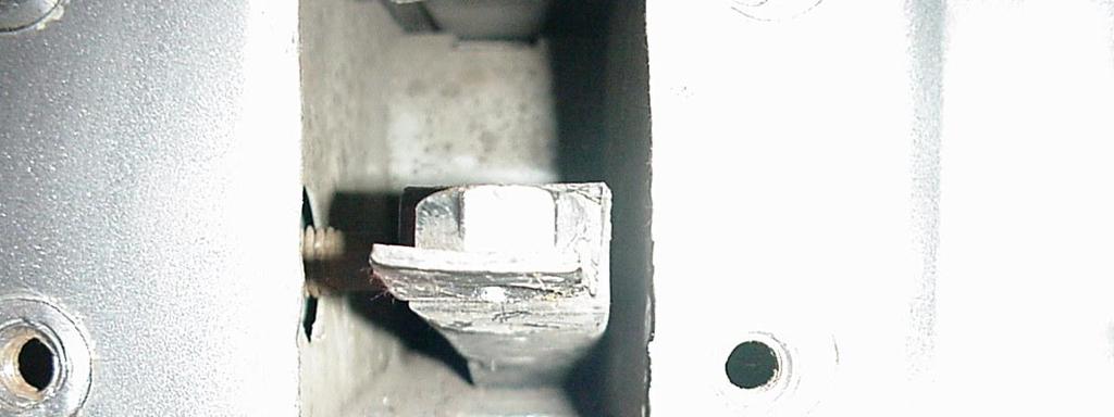 4. After removing the bolts, pry up the nut plate located inside the sub-frame. This plate is riveted to the bottom of the sub-frame. Use a chisel and hammer to break the rivet.