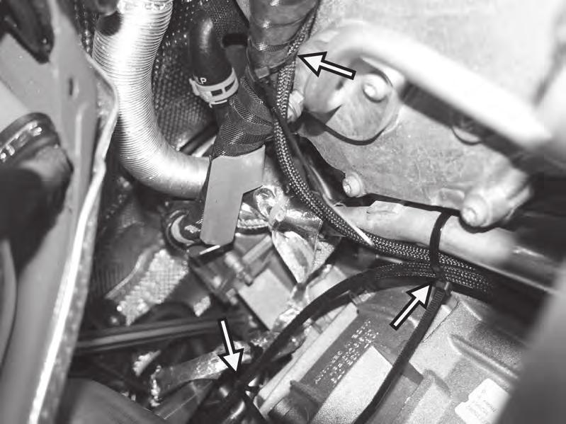 32) On the left side on top of the transmission, secure the left APR harness to the large factory harness on the back
