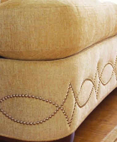 A double row of nailhead trim is repeated on the arms and back to highlight the soft curves of the