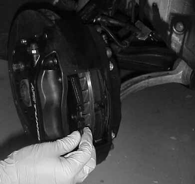 23.Slide a brake pad between the caliper and rotor on the outboard side. Be sure that the friction surface is facing the rotor.