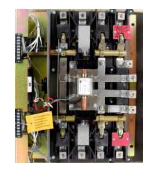 Transfer switch mechanism Transfer switch mechanism is electrically operated and mechanically held in the source 1 and source 2 positions.