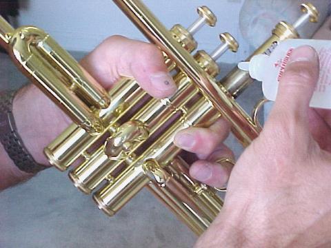 OILING THE VALVES - do this about 2 times a week. 1. Hold your trumpet exactly like you would when you play it but hold it at a 45 degree angle downward. 2. Unscrew the valves top cap and lift the valve only half way out of the casing.