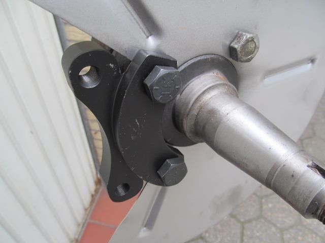 Insert one of the brake calliper holders at the top using one of the included long screws for brake calliper holders. Use one of the new, short screws at the bottom.
