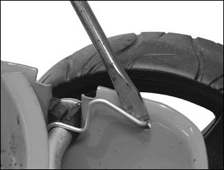 Remove the axle by withdrawing the retainer screw or unhooking the W clip by pressing down with a screwdriver as appropriate.