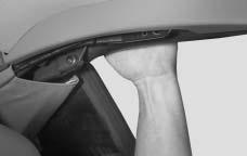 19. While holding the rear of the top down, insert the wrench into the bolt in the plug opening in the headliner.