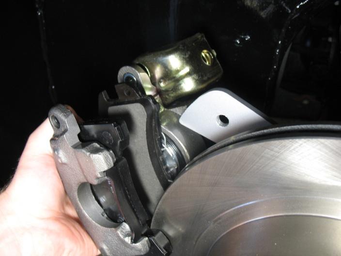 Slide the caliper into position, have the brake pads go on each side of the rotor and the two mounting holes
