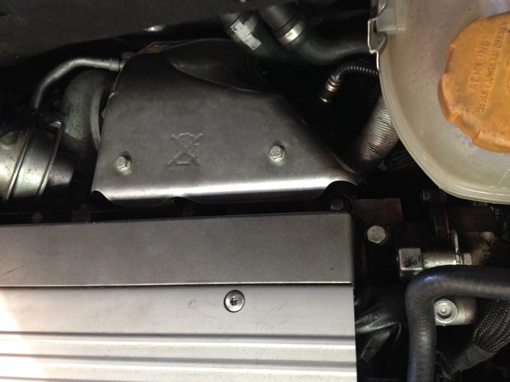 4. Open the hood and remove the two bolts holding the turbo heat shield on with a