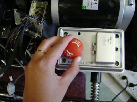 Figure 125: Releasing the emergency power shut-off button. 7. Ensure that the forward/reverse, steering wheel/joystick and training/normal switches are in the desired positions. 8.