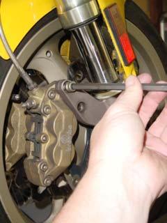 This document provides instructions for removing and installing a Front Wheel / Rotor on a Ducati Superbike.