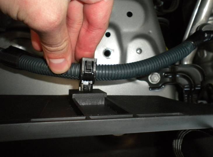 Install the OEM clip removed in step C8 on the wire harness in the location