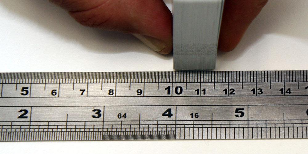 If a vernier caliper is not available it is possible to measure card thickness using a standard ruler. Hold a full deck (52 cards) and measure thickness as shown below. Then divide the result by 52.