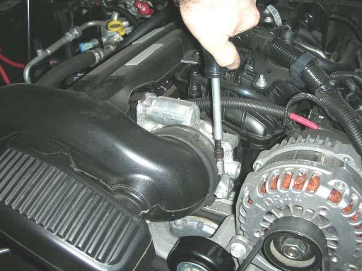 Remove the plastic engine cover by lifting up at the front and