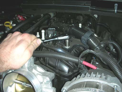 21. Remove the wiring harness bracket from the intake manifold by removing the nut with