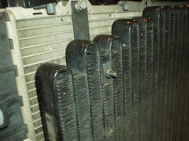 The longer bolts sticking through the AC condenser now provide a mounting location for the supplied FMIC