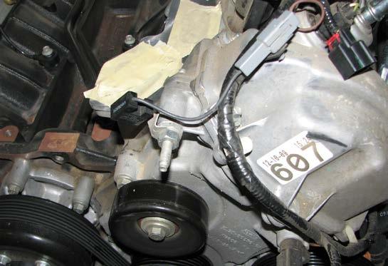 49. Use an 8mm socket to unbolt and remove the water crossover from the engine. Remove the gaskets on each end and retain them, as they will be reused. Then place making tape over each water passage.