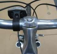 If your bike came with a handlebar-mounted front reflector (white), remove the reflector mounting screw and gently open the bracket enough to slide over the handlebar on the left side of the stem
