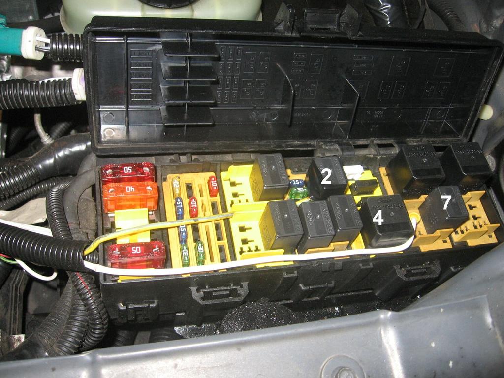 Further research shows that the Green/Yellow input to the inertia switch is from the fuel pump relay, which is located in the fuse box under the hood.