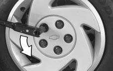 Removing the Flat Tire and Installing the Spare Tire If your vehicle has a bolt-on wheel cover, loosen the plastic caps using the wheel wrench and remove the